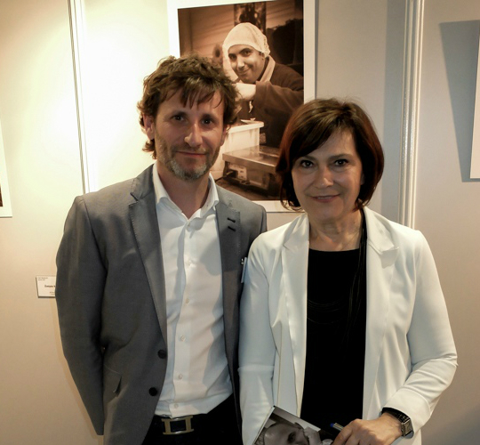 Le photographe Philippe Romeyer (à gauche), aux côtés de Mme Carlotti, Ministre déléguée aux personnes Handicapées, tenant dans les mains la brochure de présentation de l’exposition